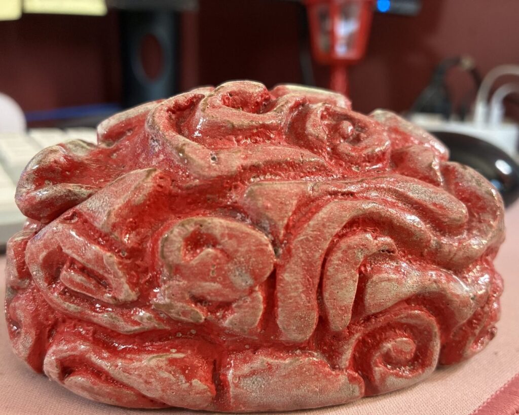 Red glazed ceramic brain sculpture created by Amanda Sutherland